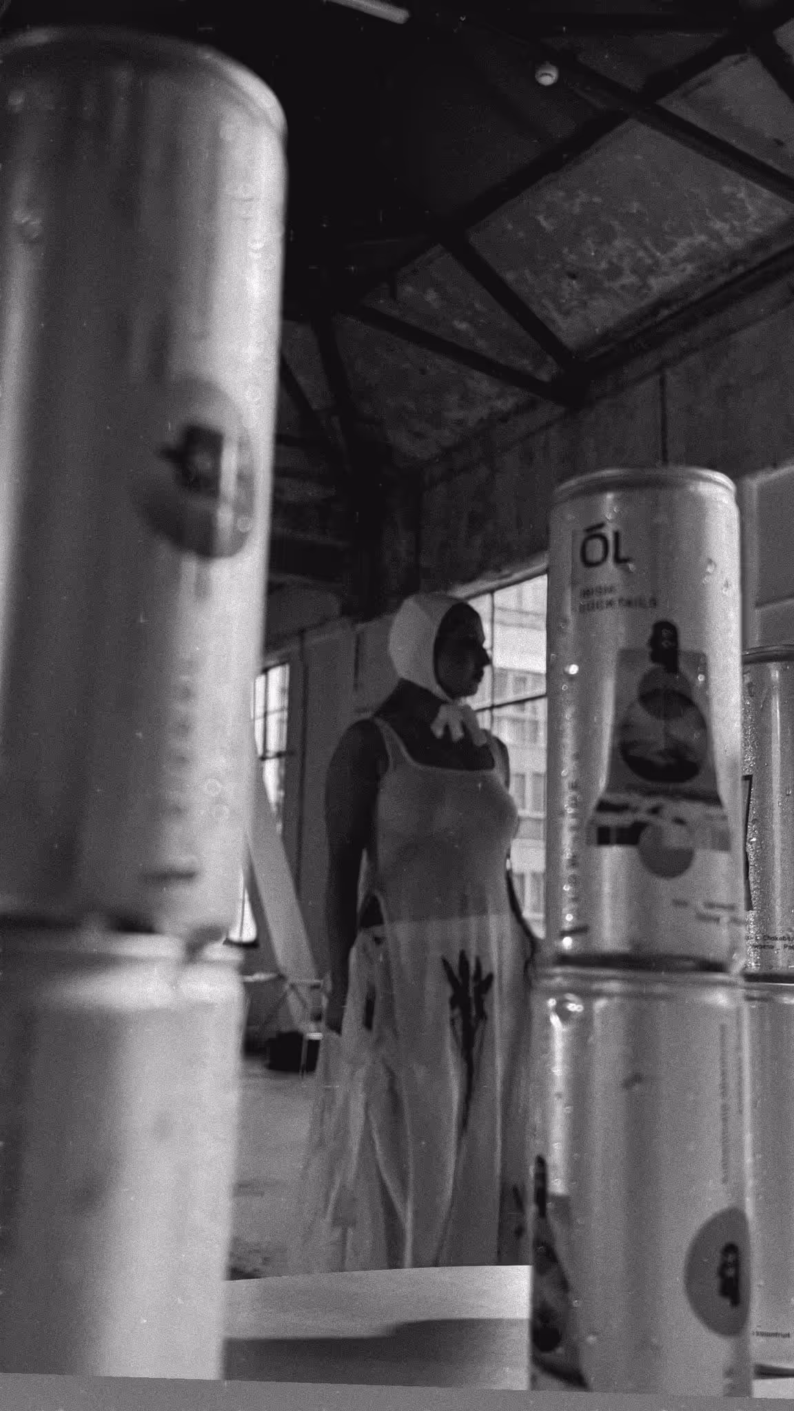 Woman standing between Ól Irish Cocktail cans